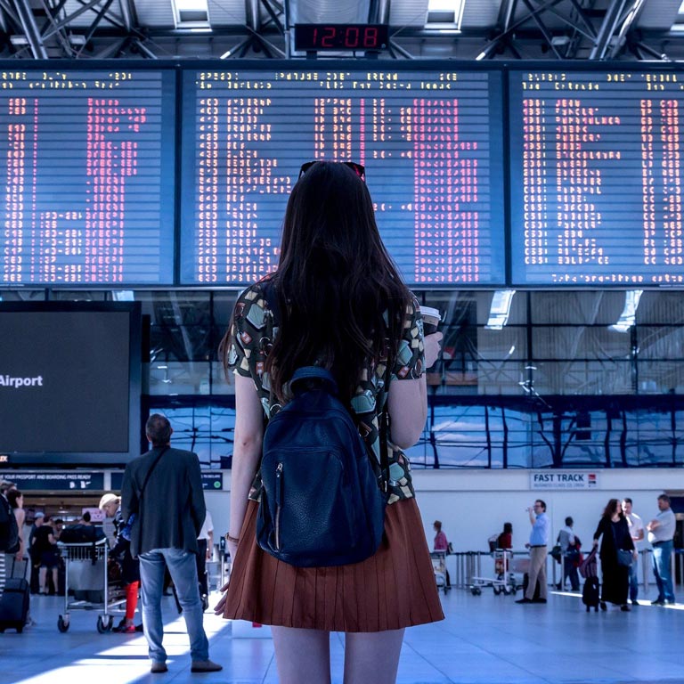 Young women in front of airport screens